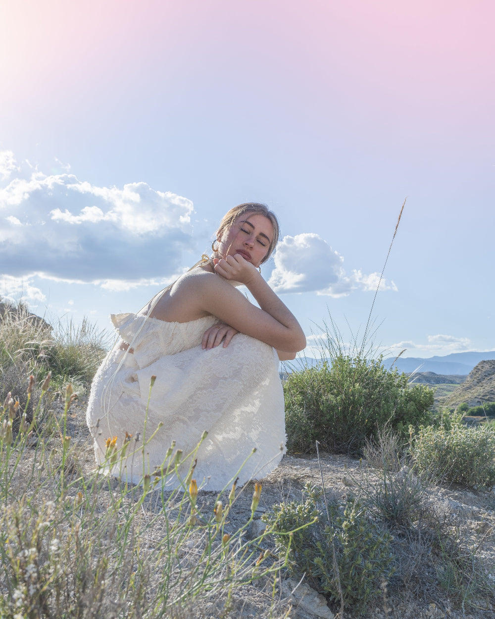 An open back top, with a flattering halter neckline, made from a gorgeous lightly see-through, fluffy, ruffled fabric in creamy white.