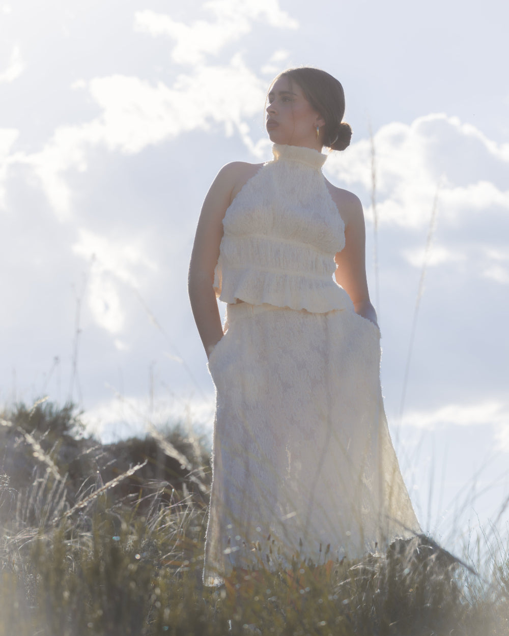 An open back top, with a flattering halter neckline, made from a gorgeous lightly see-through, fluffy, ruffled fabric in creamy white.